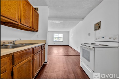 A kitchen with wooden cabinets and a white stove top oven.