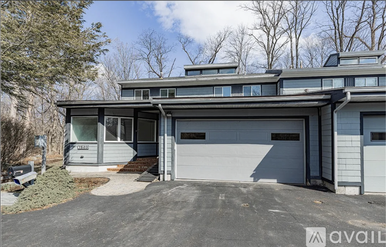 A modern house with a grey exterior and a large garage door.