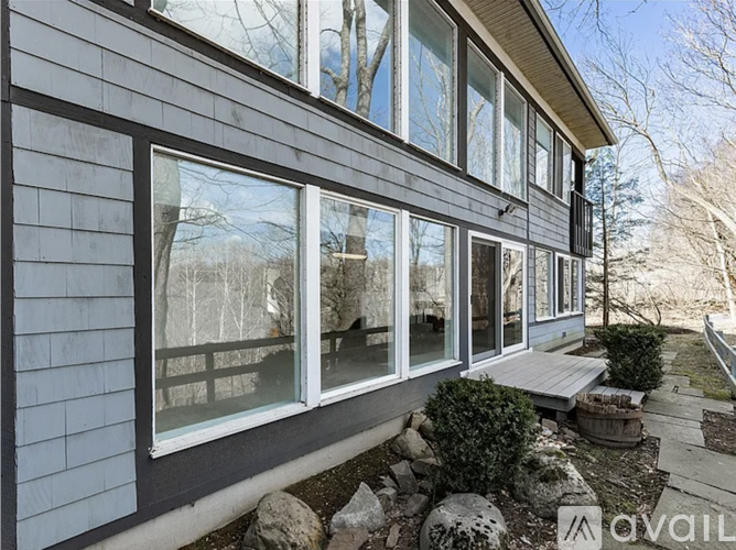 A house with a grey siding and a large window.
