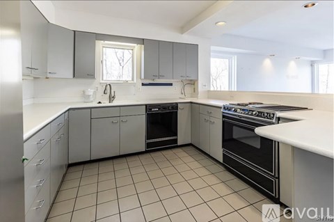 A kitchen with white cabinets and black appliances.