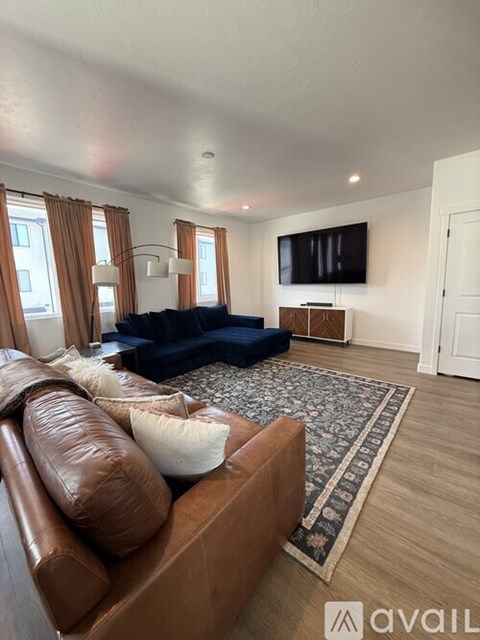 A living room with a brown leather couch and a blue sofa.