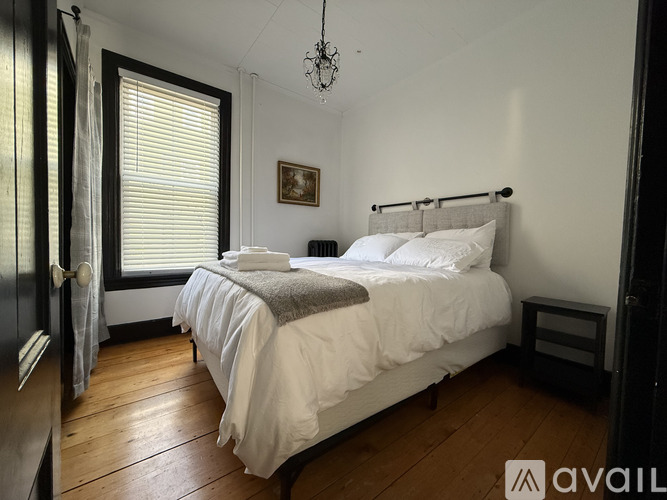 A bedroom with a large bed and a chandelier.
