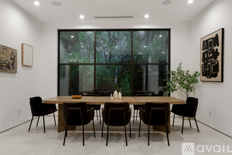 A dining room with a wooden table and chairs.