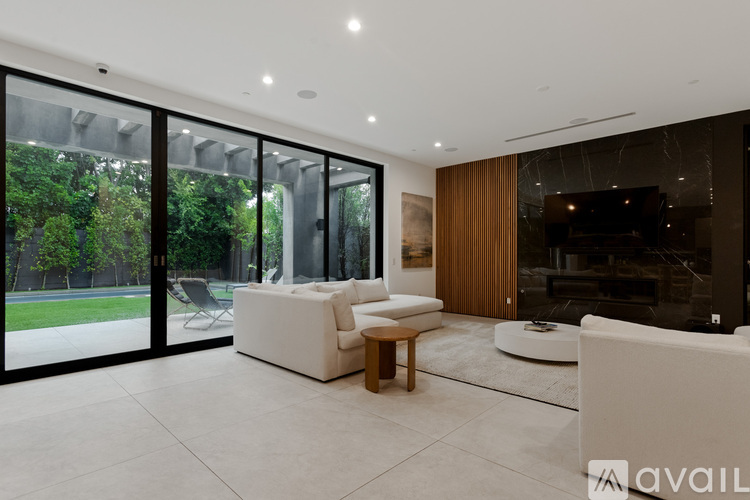 A modern living room with a white sofa and a glass wall.