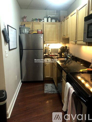 A kitchen with wooden cabinets and a black countertop.