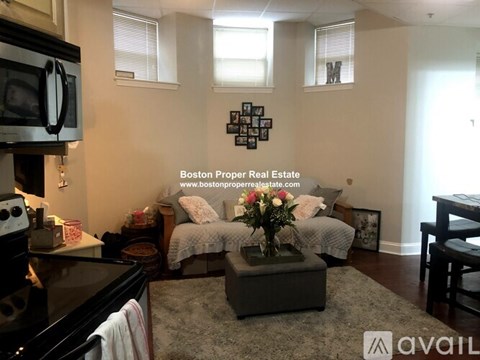 A living room with a grey couch and a coffee table in the middle.