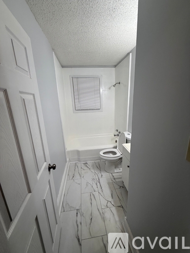 A bathroom with a toilet, sink, and a marble floor.