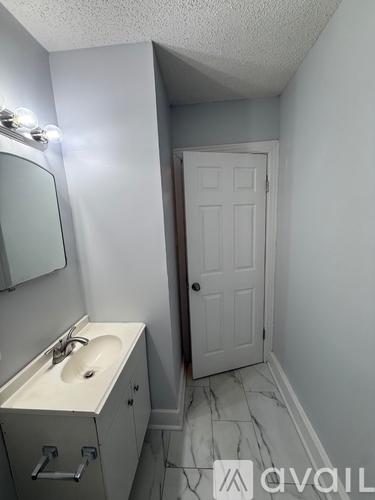 A small bathroom with a sink and a door.