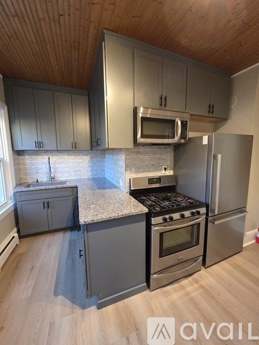 A kitchen with a stove top oven and a microwave above it.