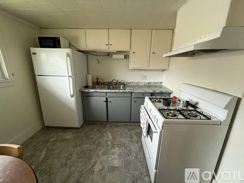 A kitchen with a white refrigerator, a white stove, and a white oven.