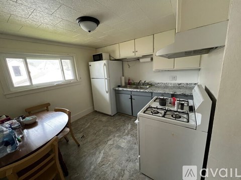 A kitchen with a stove, refrigerator, and table.
