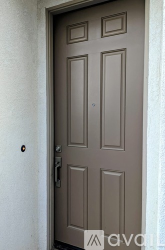 A brown door with a silver handle and lock.