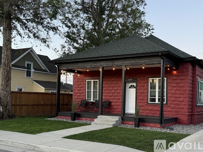 A small red house with a porch and a white door.