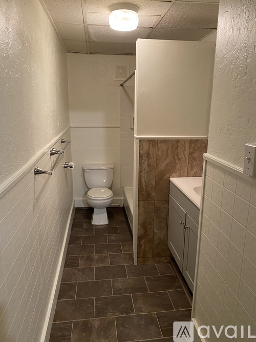 A bathroom with a toilet, sink, and tiled floor.