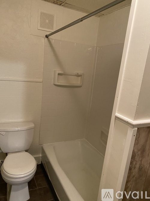 A white toilet in a small bathroom with a glass shower door.