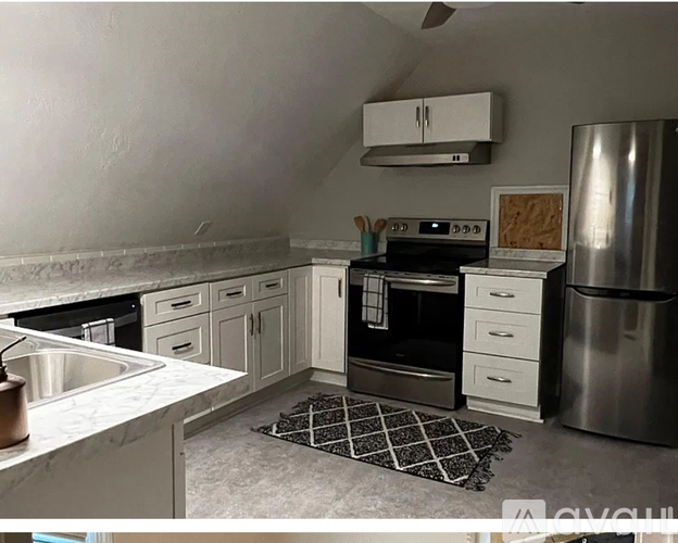 A kitchen with a stove top oven and a refrigerator.