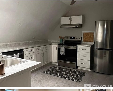 A kitchen with a stove top oven and a refrigerator.