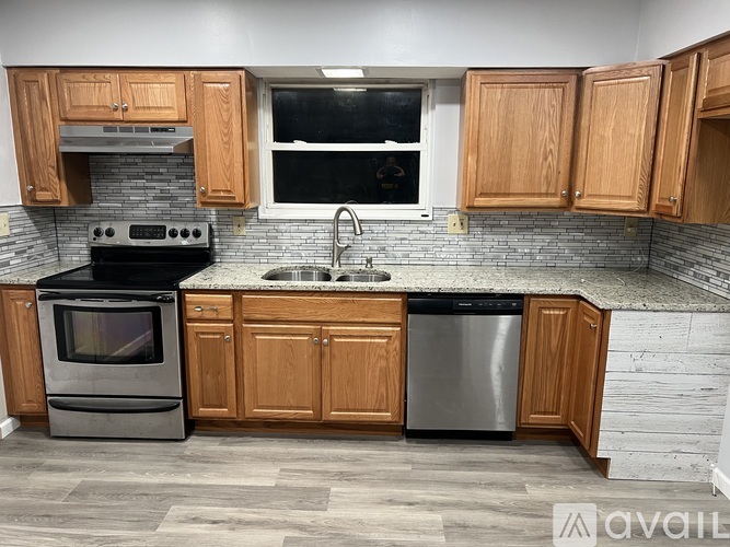 A kitchen with wooden cabinets and a black stove top oven.
