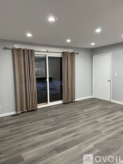 A room with a sliding glass door and a white door.