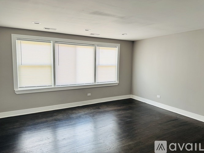 A room with a large window and wooden flooring.