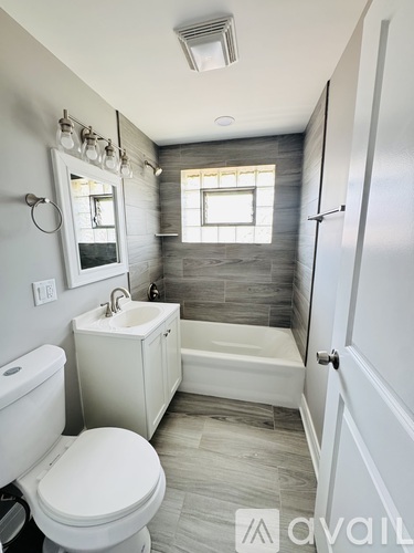 A white toilet sits next to a white sink in a bathroom.