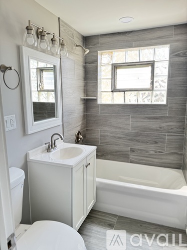 A bathroom with a white toilet, sink, and tub.