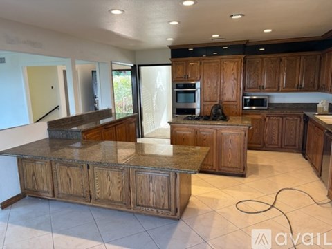A kitchen with wooden cabinets and a granite countertop.