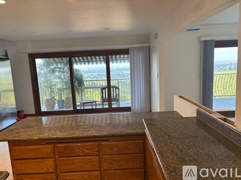 A kitchen with granite countertops and wooden cabinets.