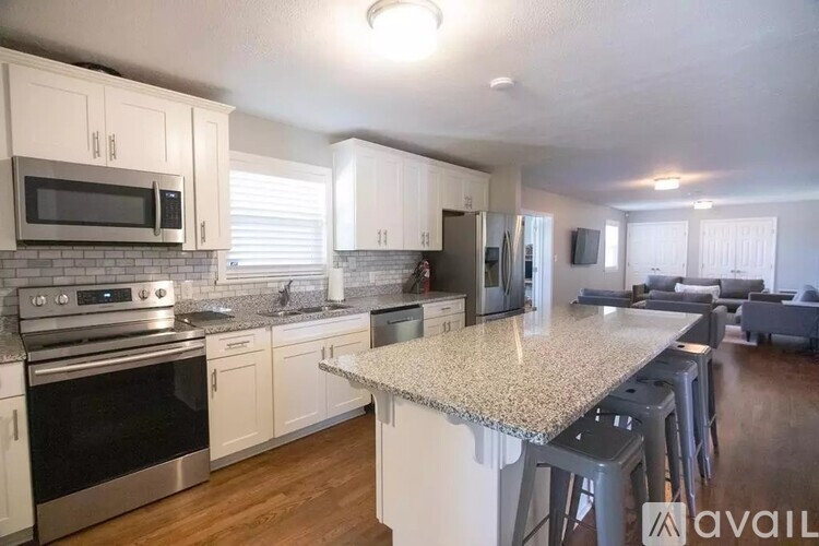 A kitchen with a granite countertop and stainless steel appliances.