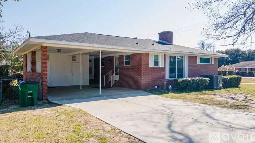 A house with a red brick exterior and a white roof is for sale.