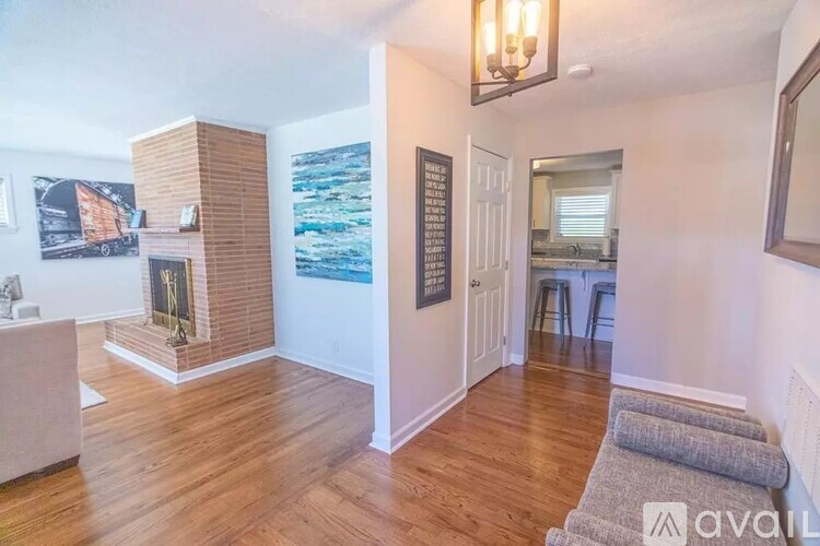 A living room with a fireplace and a painting on the wall.