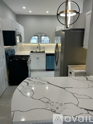 A kitchen with a marble table top and a fridge with a blue door.