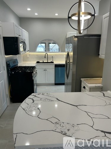 A kitchen with a marble table top and a fridge with a blue door.