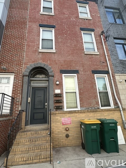 A red brick building with a black door and a sign on the wall.