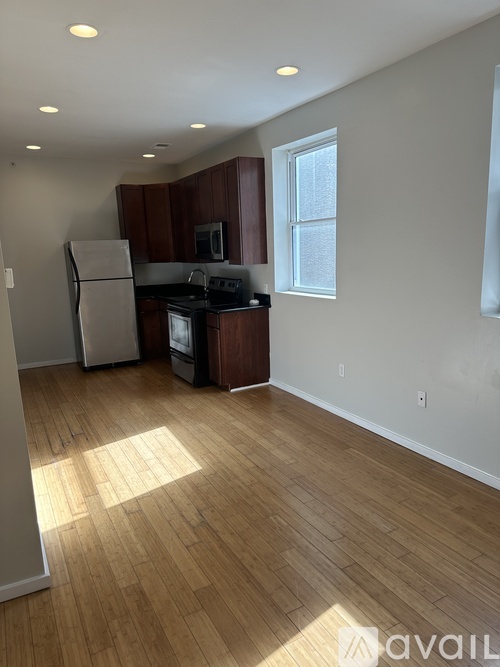 A kitchen with wooden floors and a refrigerator.