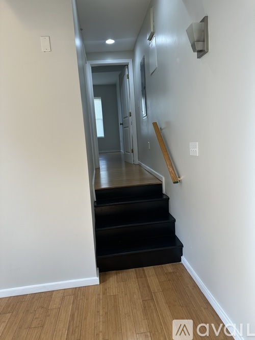 A hallway with a staircase and a door.