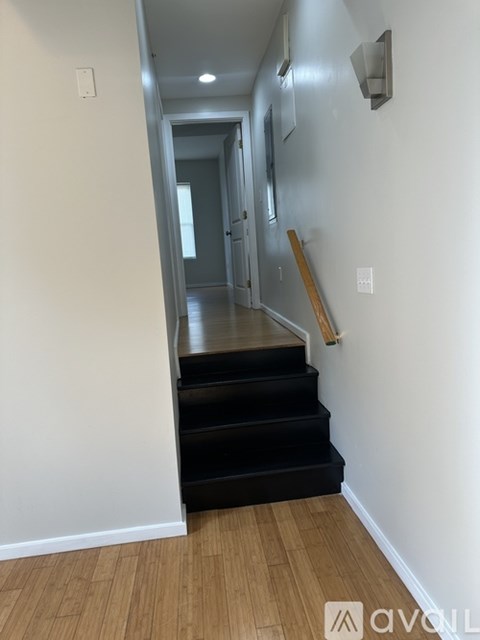A hallway with a staircase and a door.