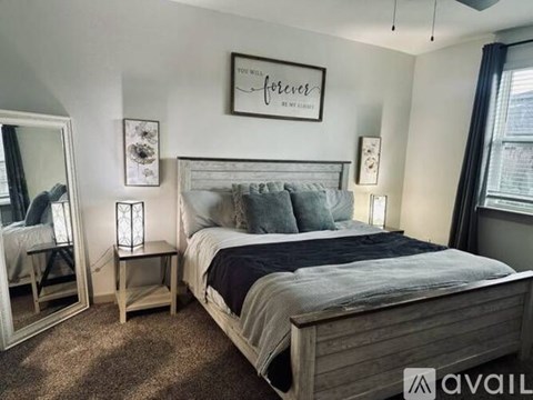 A bedroom with a large bed and a mirror on the wall.
