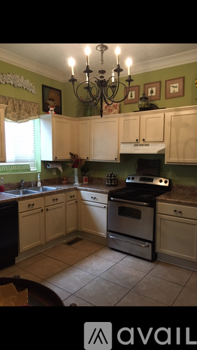 A kitchen with green walls and a chandelier.