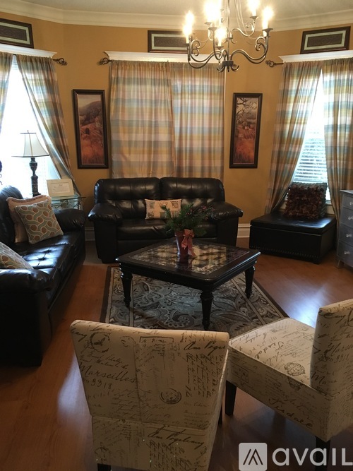 A living room with a black leather couch and a coffee table.