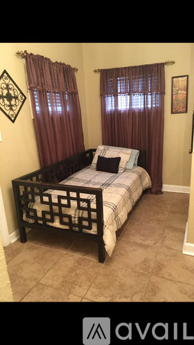 A bedroom with a bed and a picture on the wall.