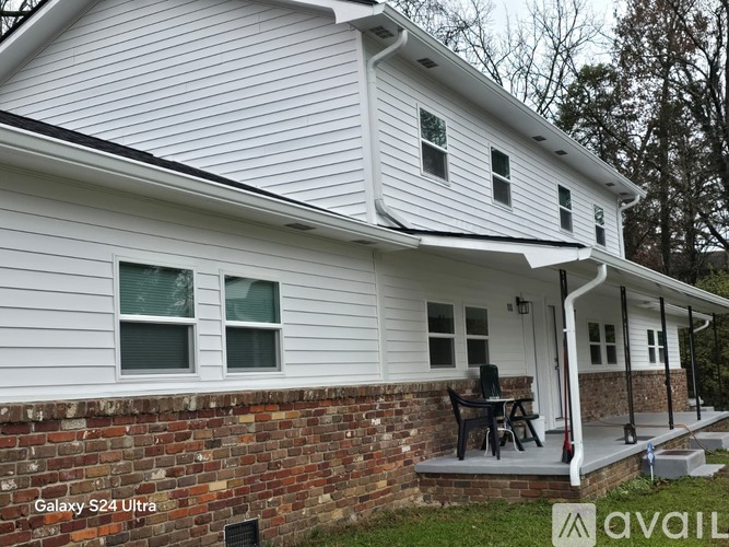 A house with a white siding and a brick wall.