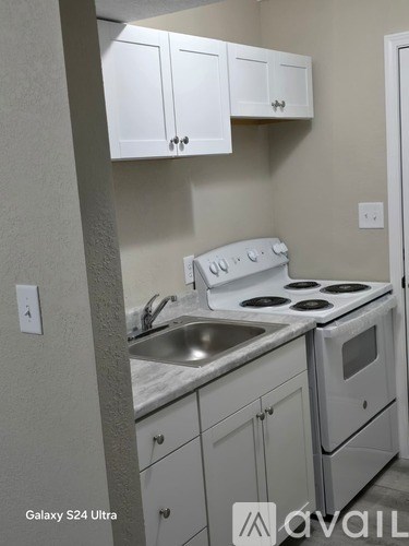 A kitchen with white cabinets and a stove top oven.