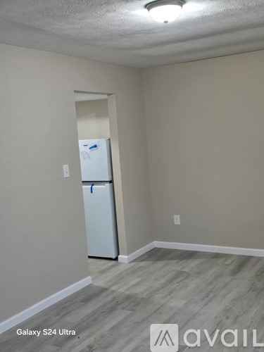 A kitchen area with a white fridge and a light on the ceiling.
