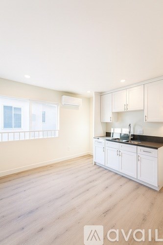 A kitchen with white cabinets and a black countertop.