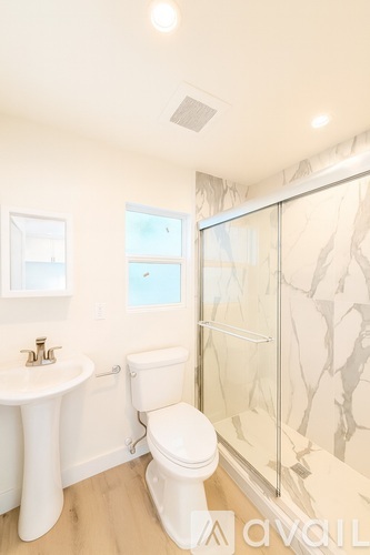 A white toilet sits next to a sink in a bathroom.