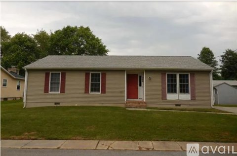 A house with a red door and two windows is for sale.