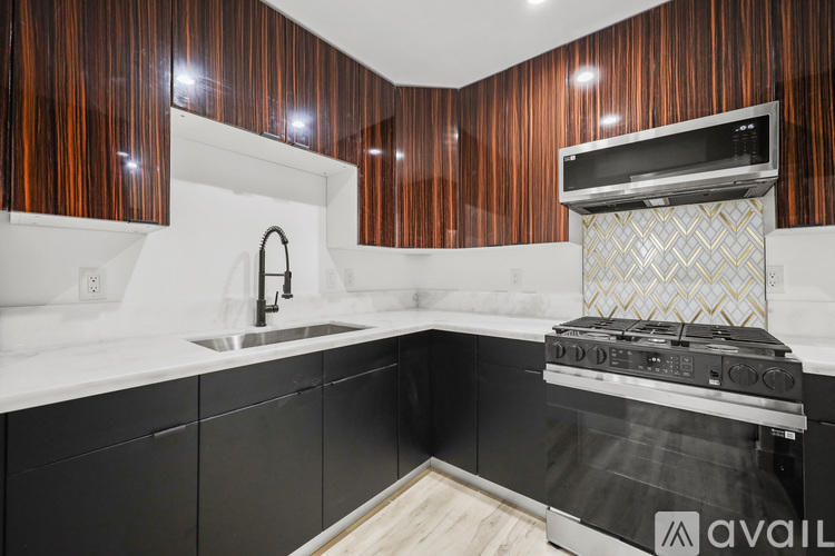 A kitchen with a black oven and wooden cabinets.