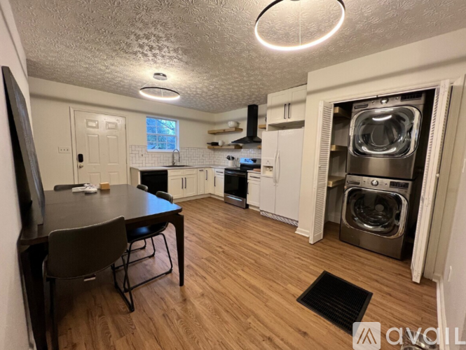A kitchen with a table and chairs and a washing machine in the background.