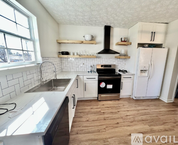 A kitchen with white cabinets and a black stove top oven.